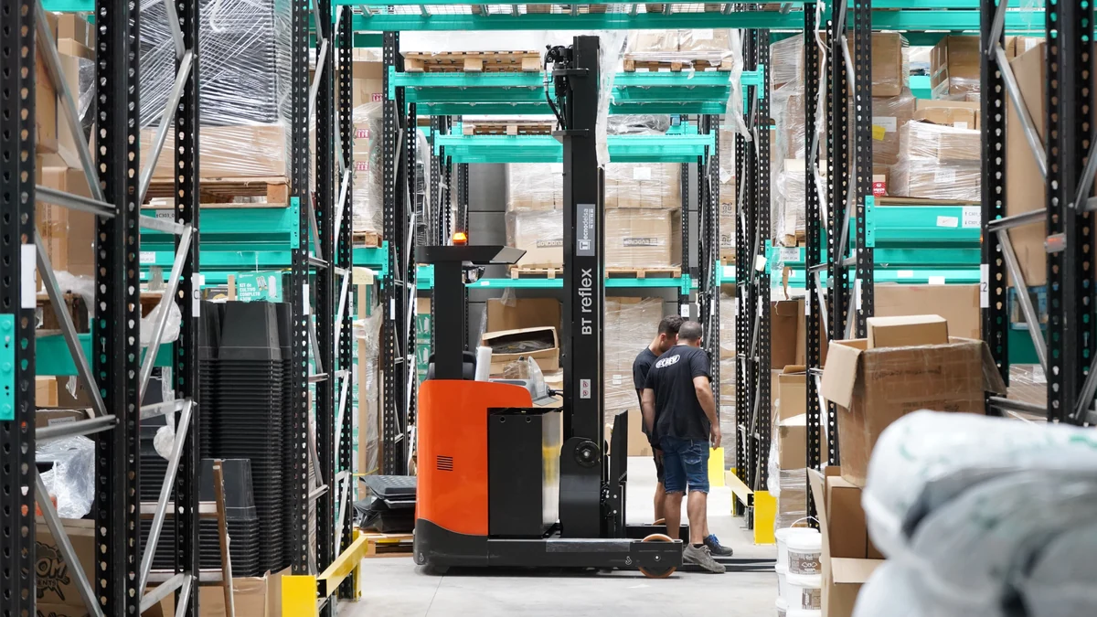 Warehouse employees working with a forklift and freight